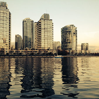 Modern city skyline with skyscrapers reflecting in calm water