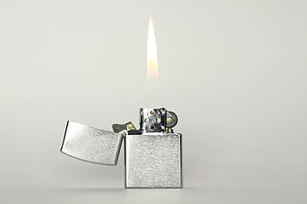Silver Flip Top Lighter with Flame on White Background