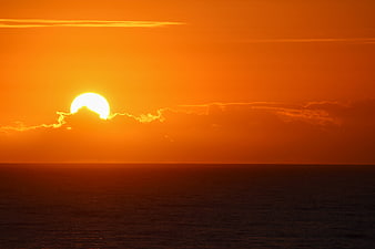 Vibrant Orange Sunset Over Calm Ocean Horizon