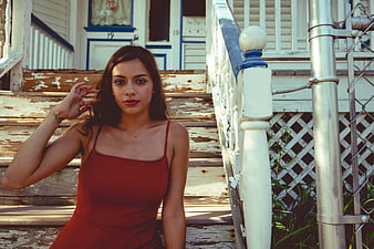 Young Brunette Woman in Red Dress on Weathered Porch Steps