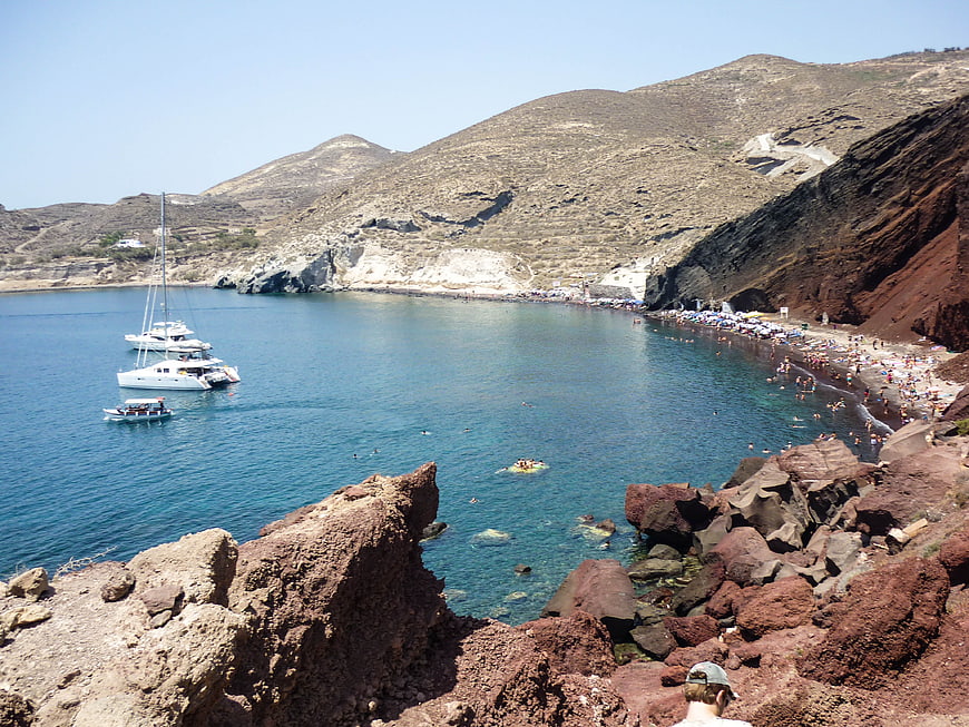 Red Beach Santorini Greece with Boats and Swimmers