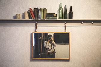 Woman taking mirror selfie with camera in vintage room
