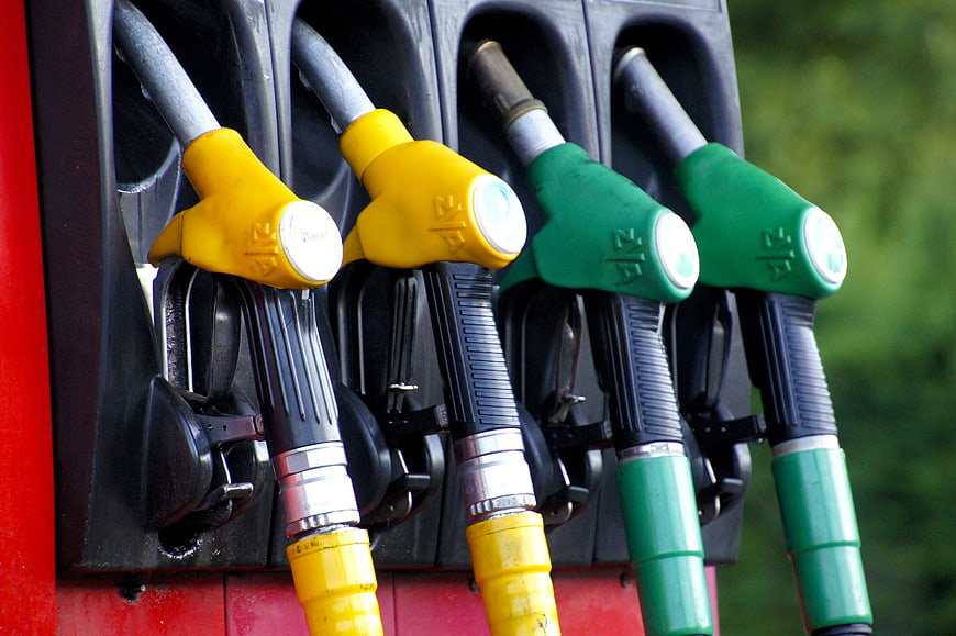 Close-up of yellow and green fuel nozzles at a gas station pump