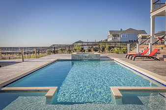 Outdoor swimming pool with deck and ocean view