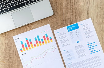 Business resume and financial charts on wooden desk