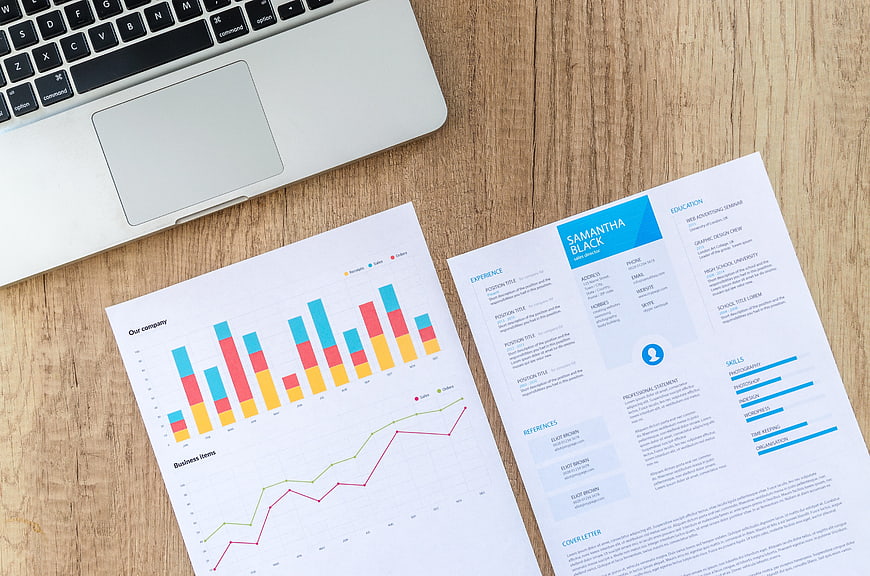 Business resume and financial charts on wooden desk