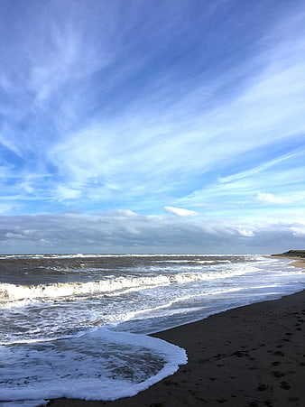 Scenic ocean coastline with waves and expansive blue sky