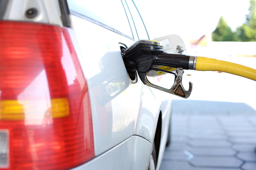 Close-up of diesel fuel nozzle refueling a white car