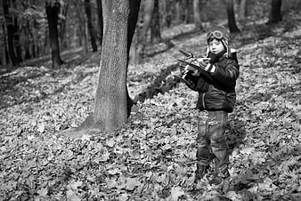 Young Boy Playing with Toy Airplane in Autumn Forest