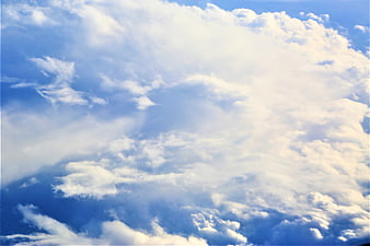 Fluffy white clouds against a bright blue sky background