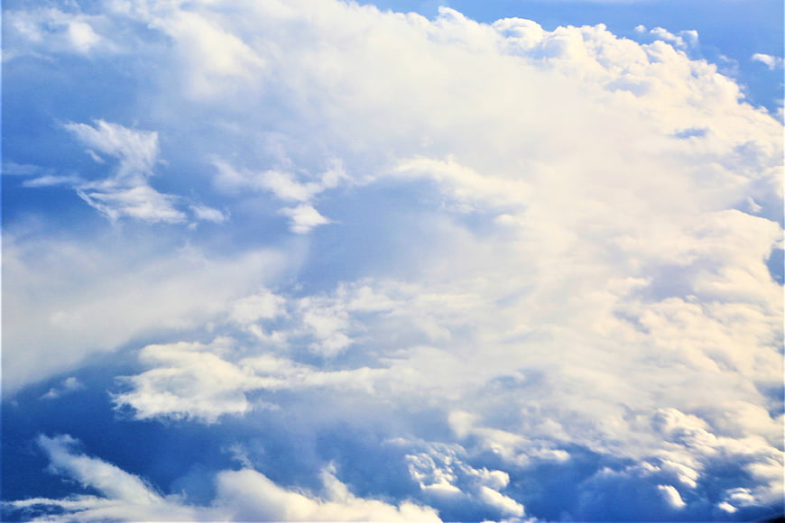 Fluffy white clouds against a bright blue sky background