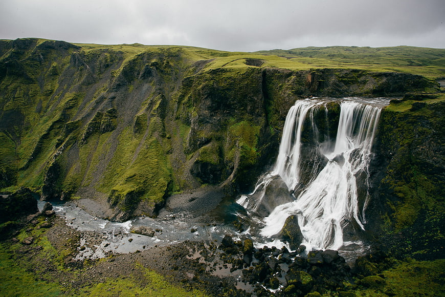 Majestic Waterfall Cascading Down Mossy Cliffs in Iceland