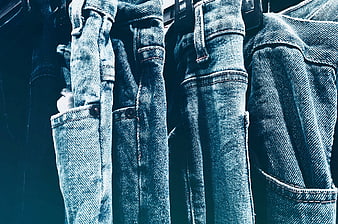 Close-up of hanging blue denim jeans on a rack