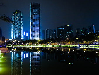 Night cityscape with skyscrapers reflected in water