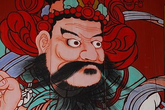 Close-up of fierce traditional Asian temple guardian deity mural