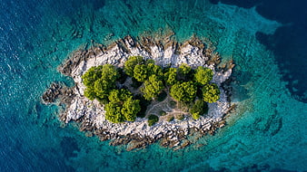 Aerial View of Small Rocky Island with Green Trees in Turquoise Sea