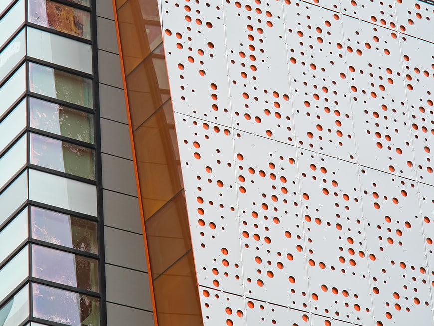 Modern Perforated Metal Facade with Orange Accents