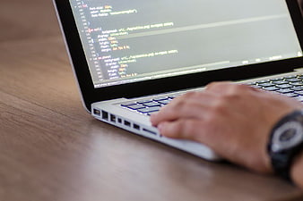 Hand Typing CSS Code on Laptop Screen