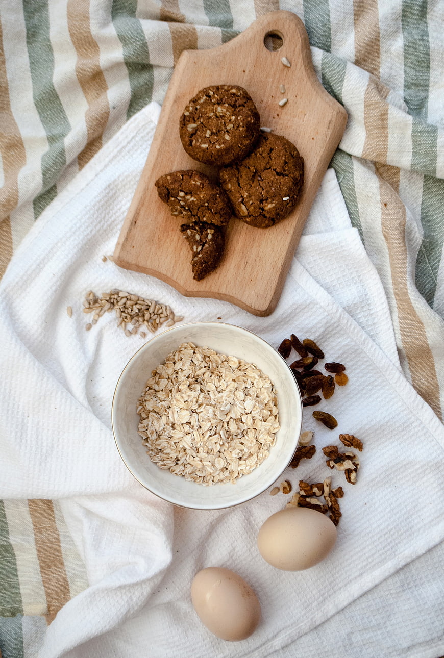 Healthy oatmeal cookies with ingredients on wooden board and linen cloth