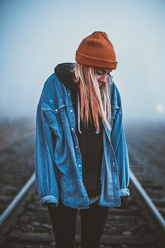 Moody Portrait of Woman in Beanie on Foggy Train Tracks