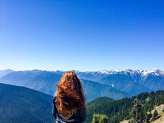 Woman with Red Hair Looking at Snowy Mountain Range