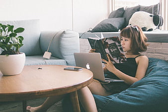 Woman Reading Book on Beanbag in Cozy Living Room