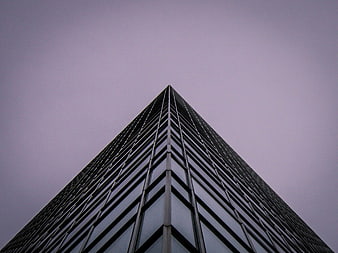 Low angle view of modern skyscraper against purple sky