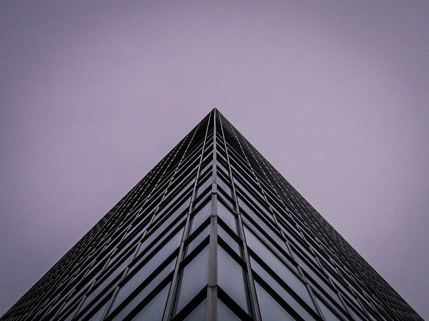 Low angle view of modern skyscraper against purple sky