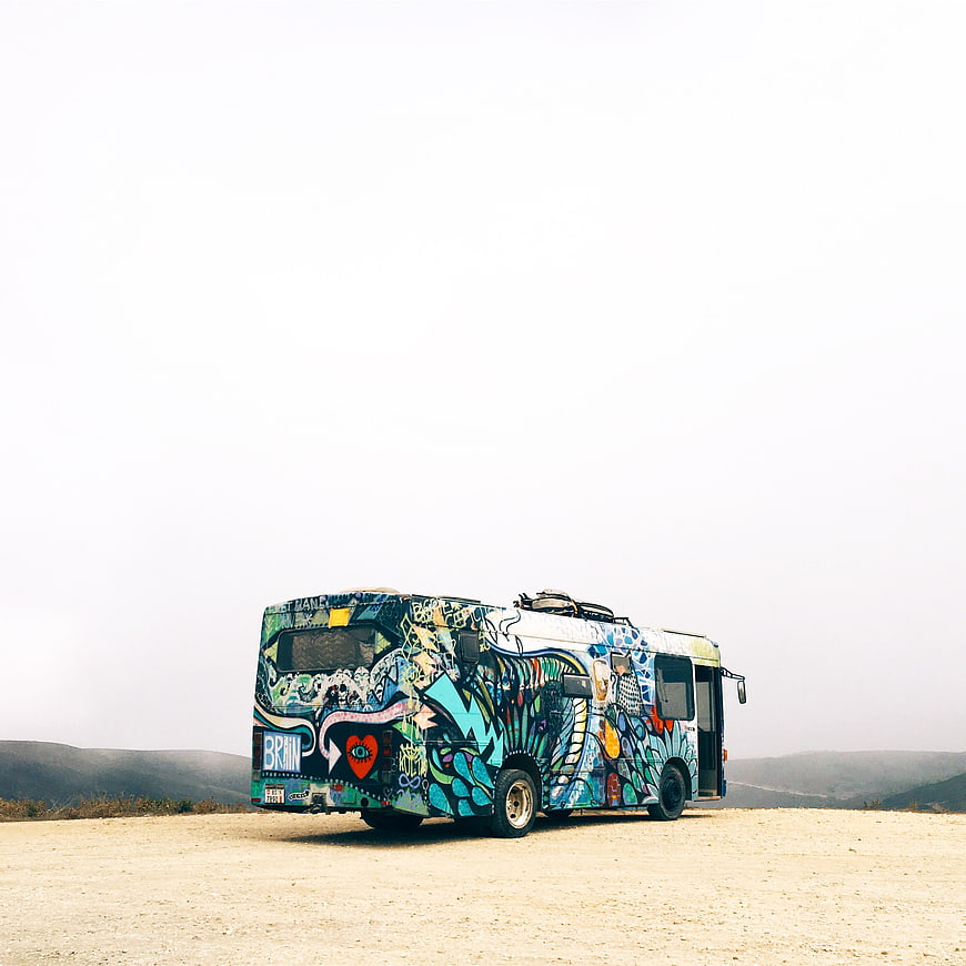 Colorful Graffiti Bus Parked in Desert Landscape