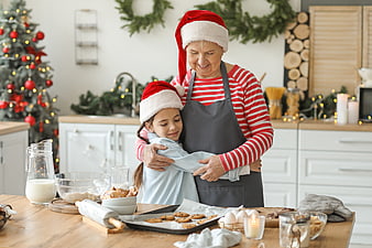 Grandmother and granddaughter baking Christmas cookies in kitchen
