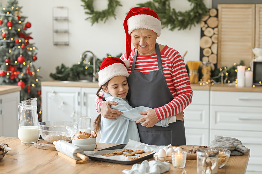Grandmother and granddaughter baking Christmas cookies in kitchen