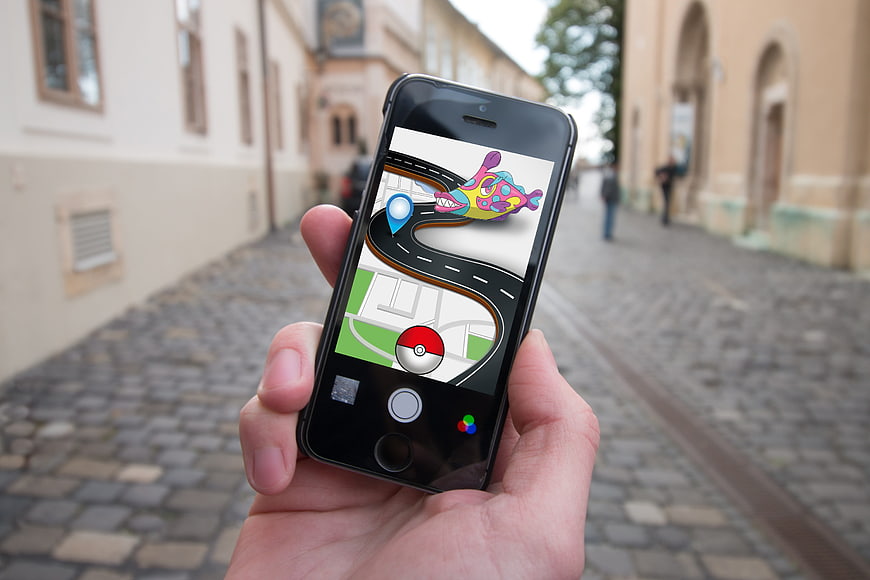 Hand holding smartphone displaying Pokemon Go game in European street