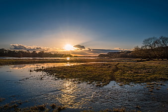 Golden Sunset Over River Floodplain with Reflections