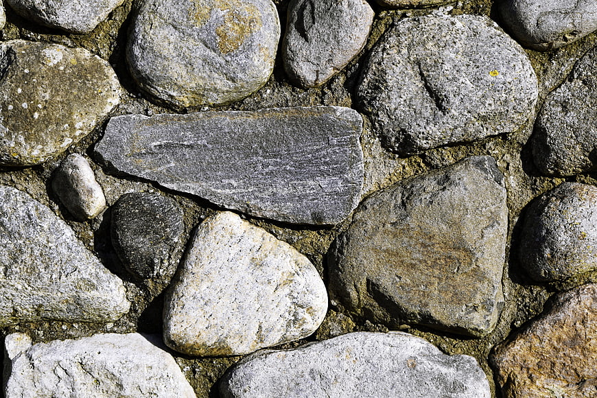 Textured natural stone wall background with varied rocks