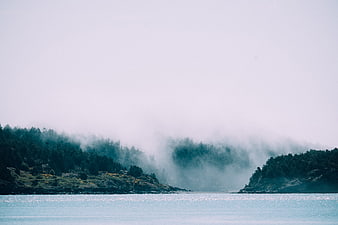 Misty Lake Landscape with Forested Hills and Fog