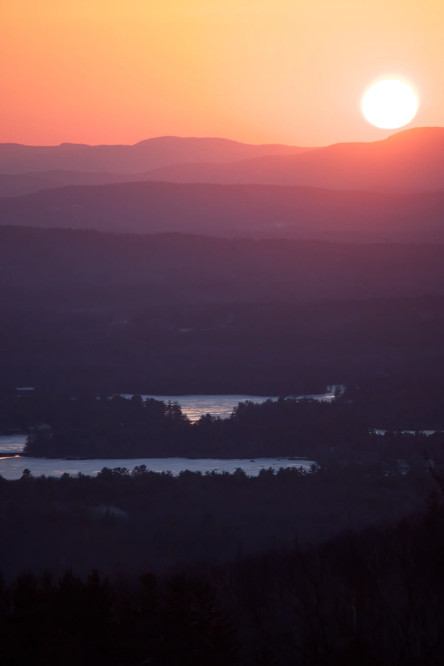 Sunset Over Layered Mountain Ranges and Lake