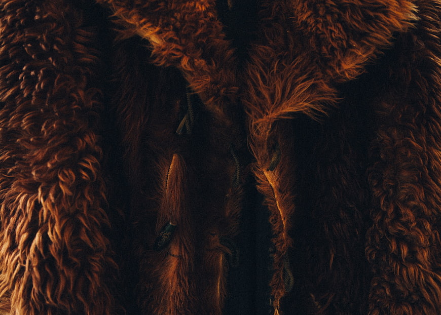 Close-up of textured brown fur coat with zipper detail