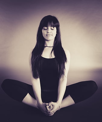 Woman meditating in lotus pose with eyes closed