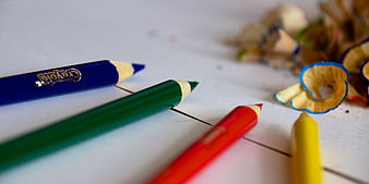 Colorful Crayola Pencils and Shavings on White Surface