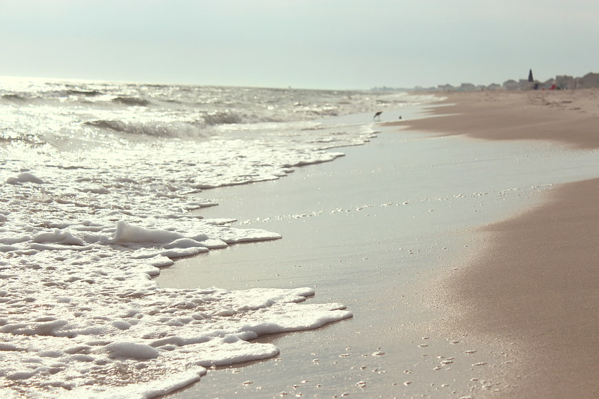 Sunny Beach Shoreline with Gentle Waves and Foamy Water