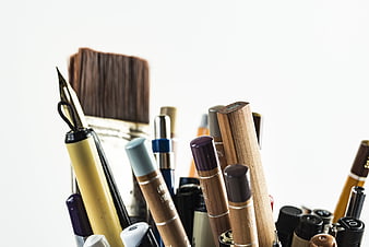 Close-up of art supplies and pens in a container
