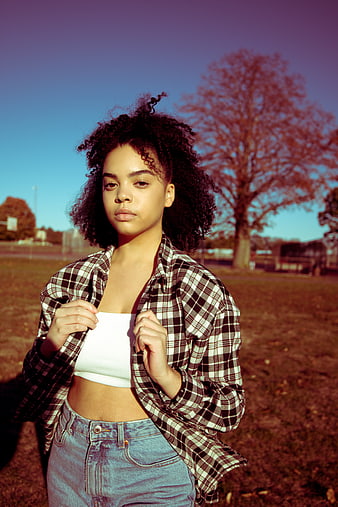Young Woman in Plaid Shirt and Jeans Outdoors