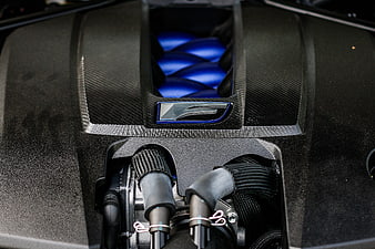 Close-up of high-performance car engine with carbon fiber and blue accents