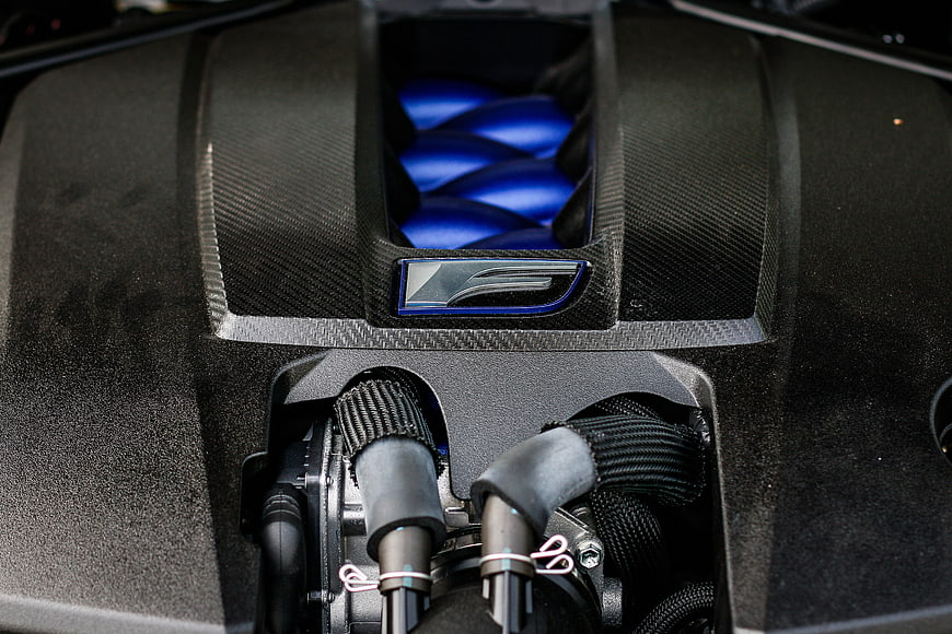 Close-up of high-performance car engine with carbon fiber and blue accents