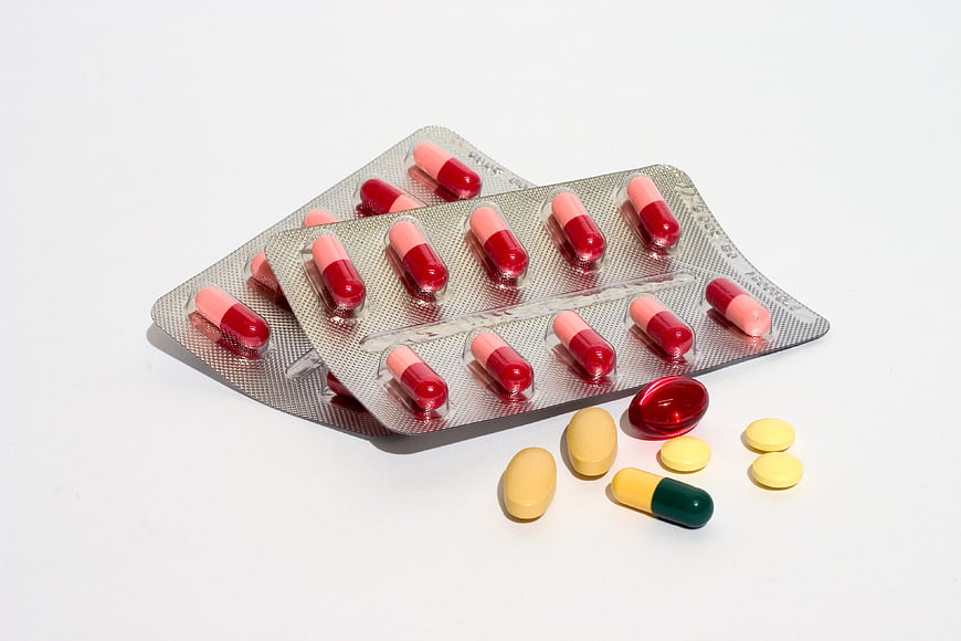 Assorted pills and capsules on white background