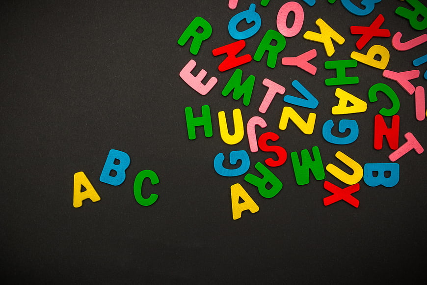 Colorful Wooden Alphabet Letters Scattered On Black Background