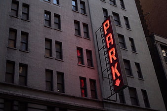 Red Neon Park Sign on Brick Building Facade