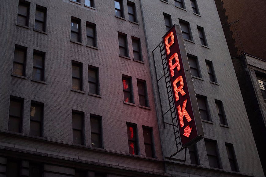 Red Neon Park Sign on Brick Building Facade