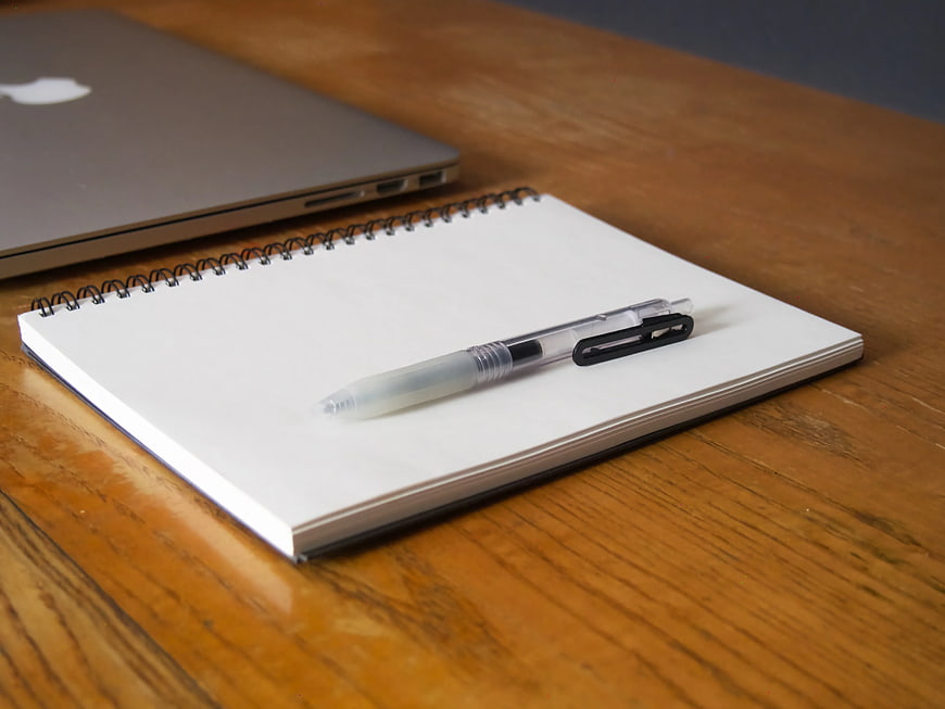 Laptop and Notebook on Wooden Desk