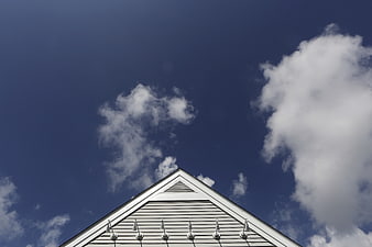 White House Gable Roof Against Blue Sky with Clouds